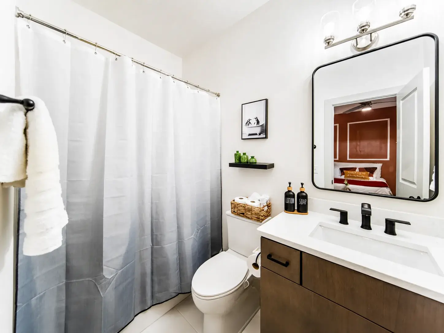 Second full bathroom with a tub shower, vanity storage and fresh towels