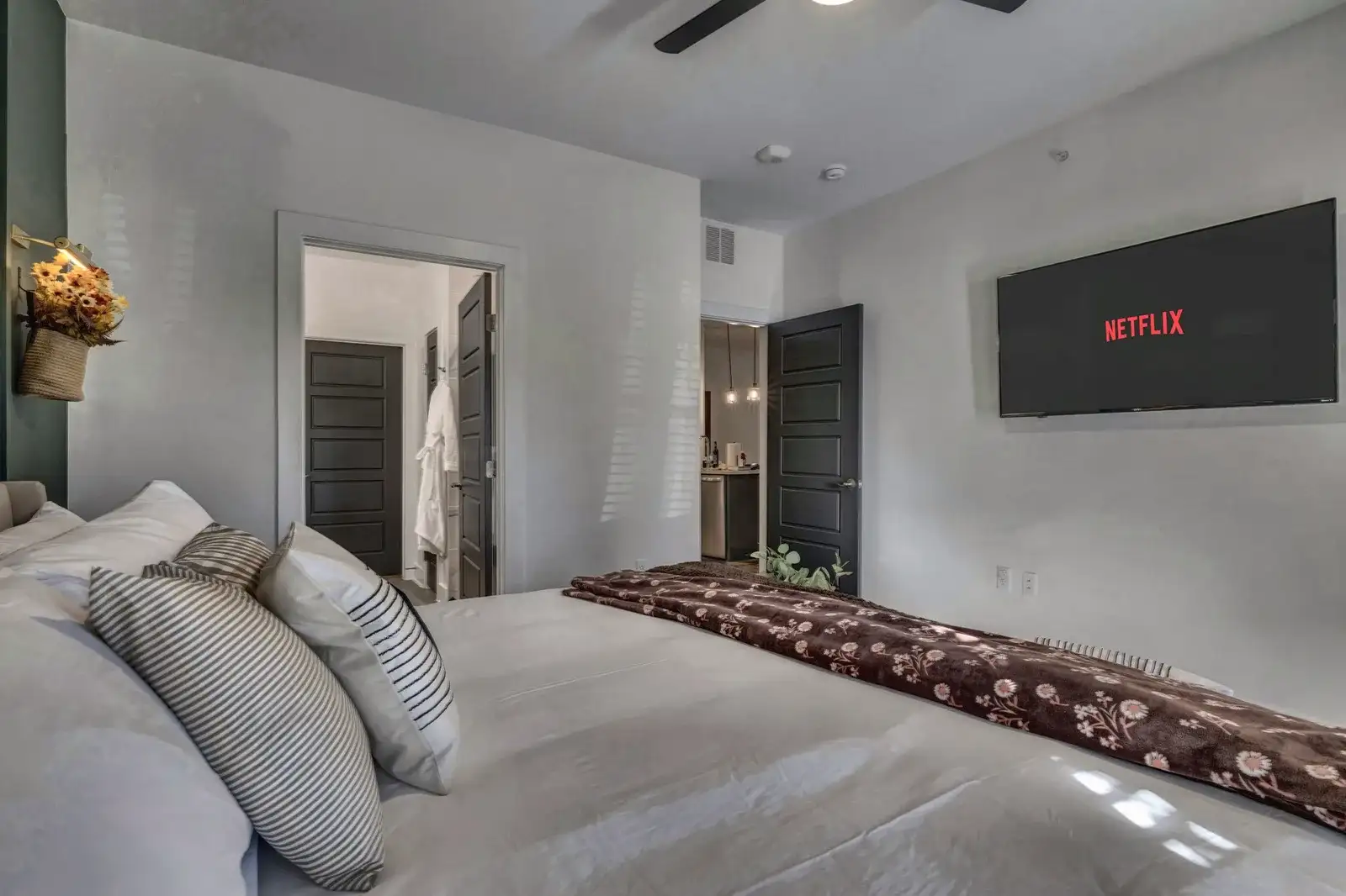 Cozy modern bedroom with plush bedding, smart TV, and ensuite access