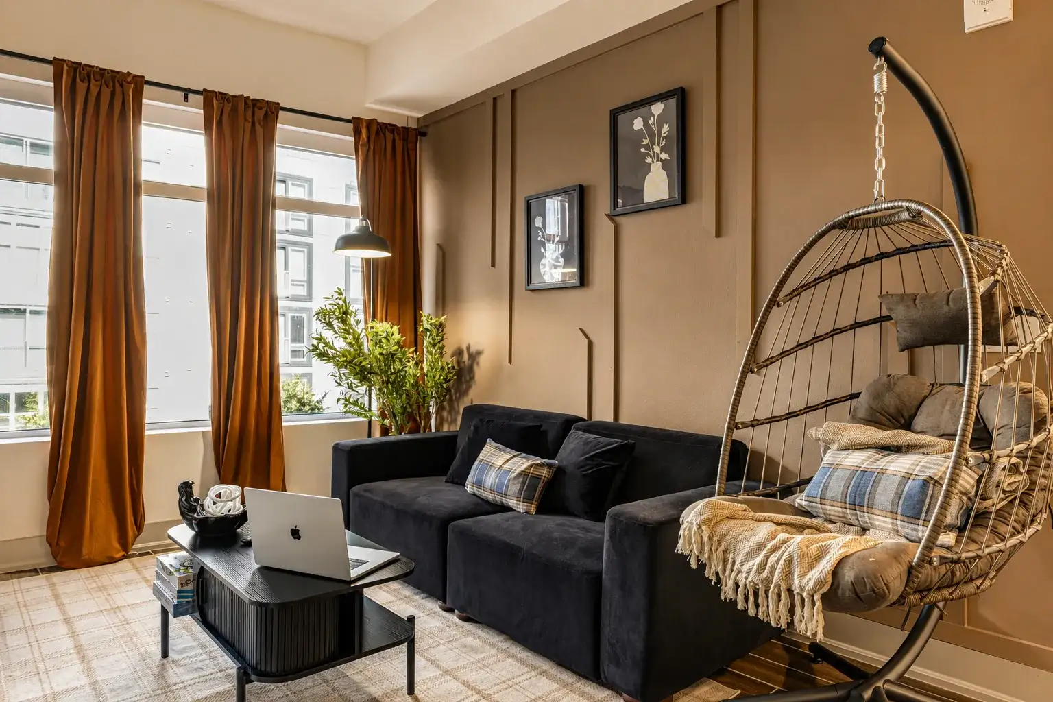 Designer living room with a velvet sofa, hanging egg chair and gallery wall