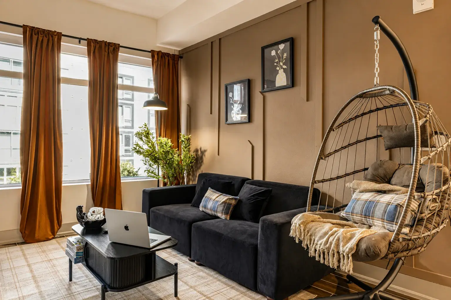 Designer living room with a velvet sofa, hanging egg chair and gallery wall