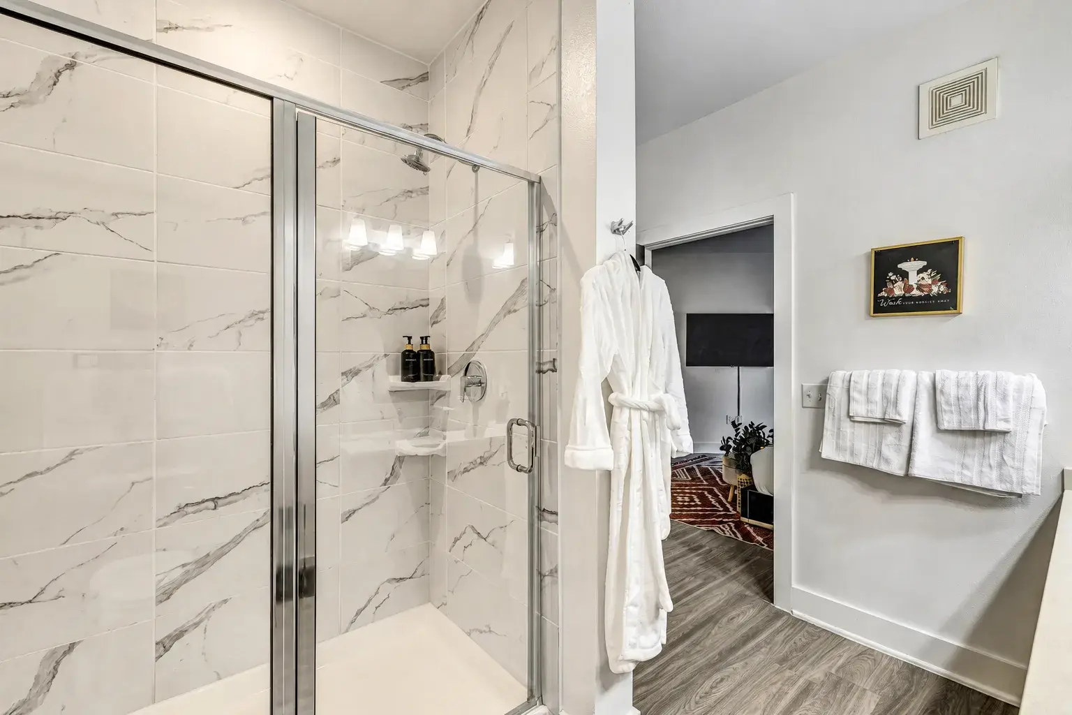 Spa-style bathroom with glass walk-in shower and elegant marble tile