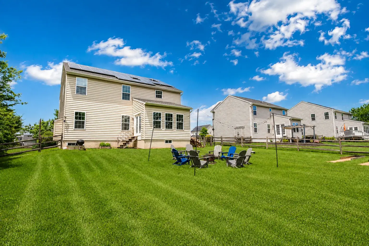 Spacious backyard with fire pit seating and room to relax under sunny skies