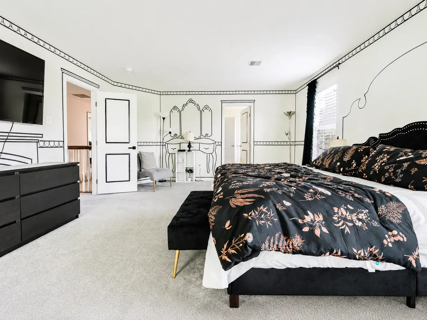 Spacious, stylish bedroom retreat with TV, seating, and elegant design