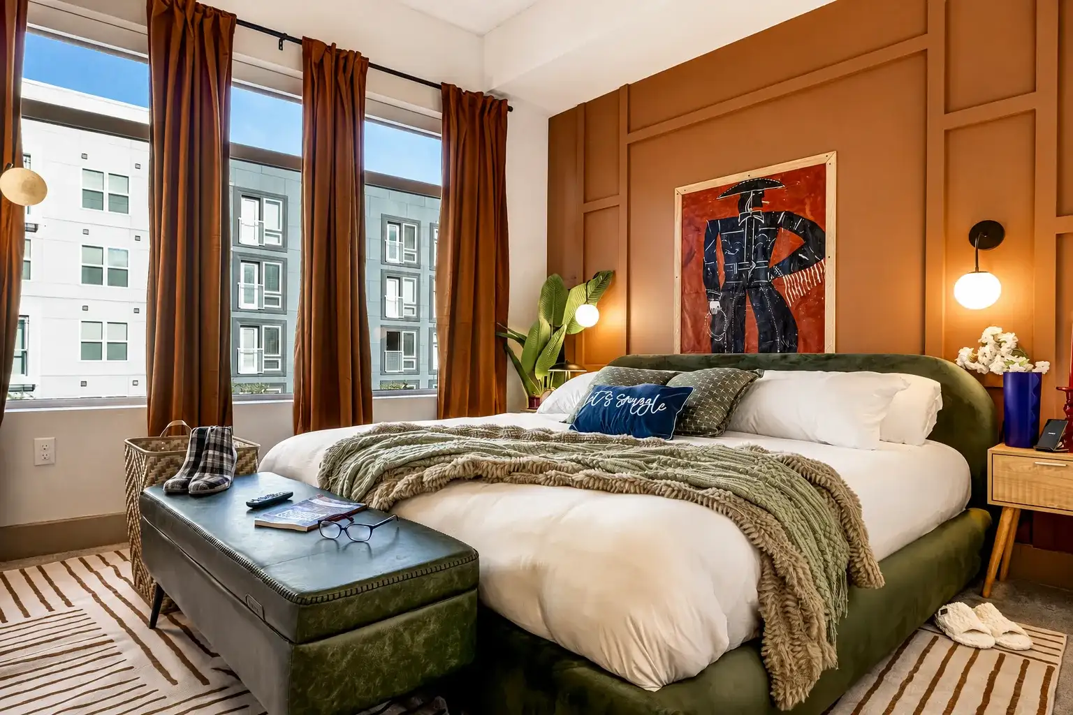 Warm, designer bedroom with tall windows, luxe linens, and modern style