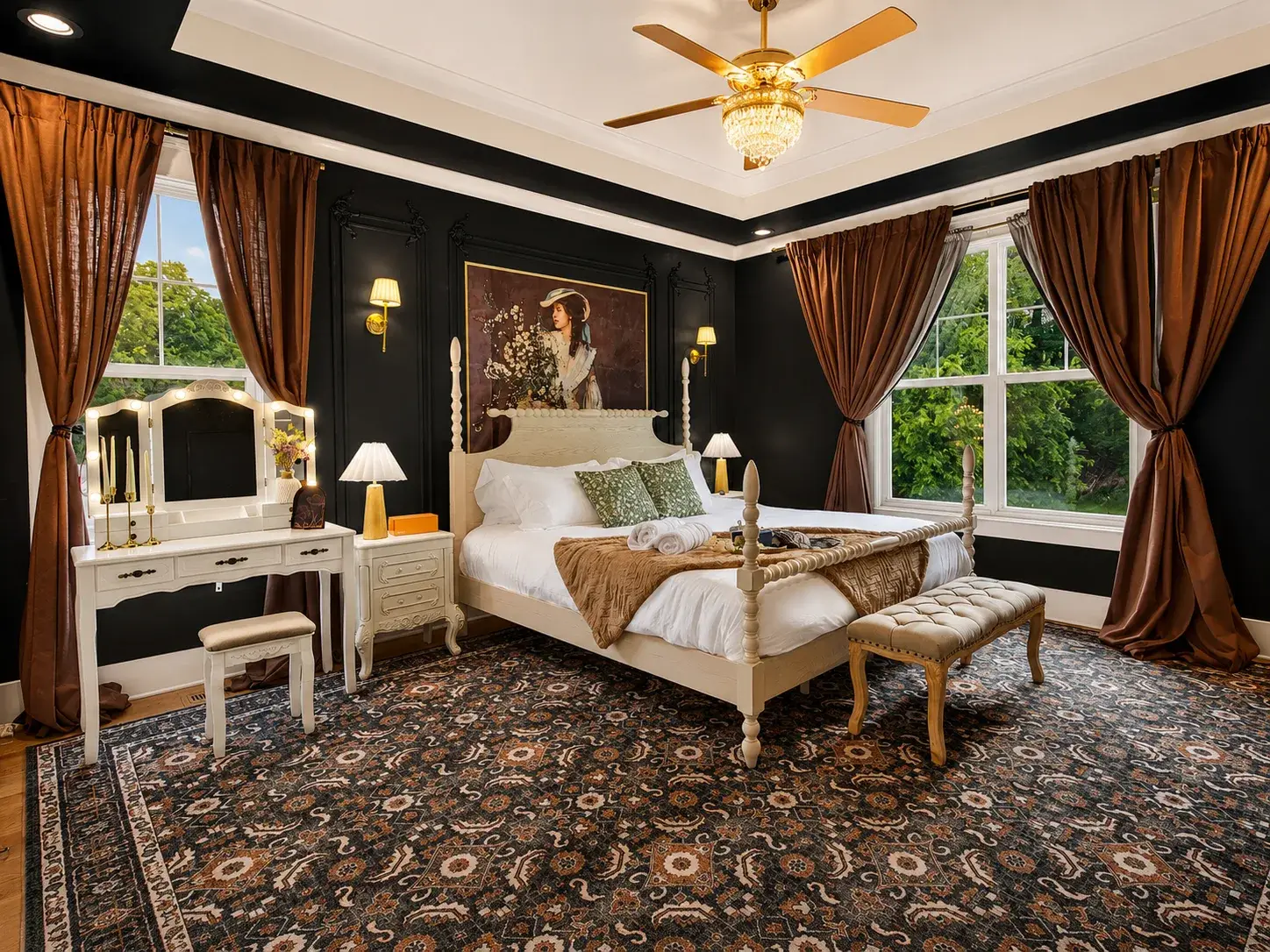 Elegant bedroom with four-poster bed, vanity, and large sunlit windows
