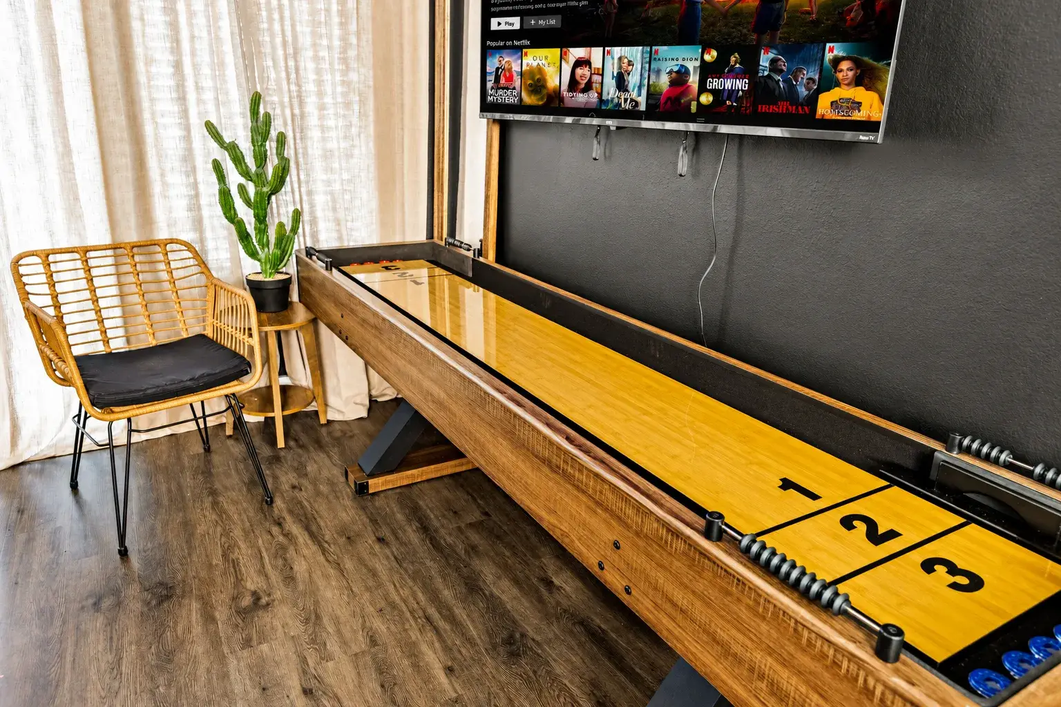 Fun game room nook with shuffleboard, TV, and stylish lounge seating