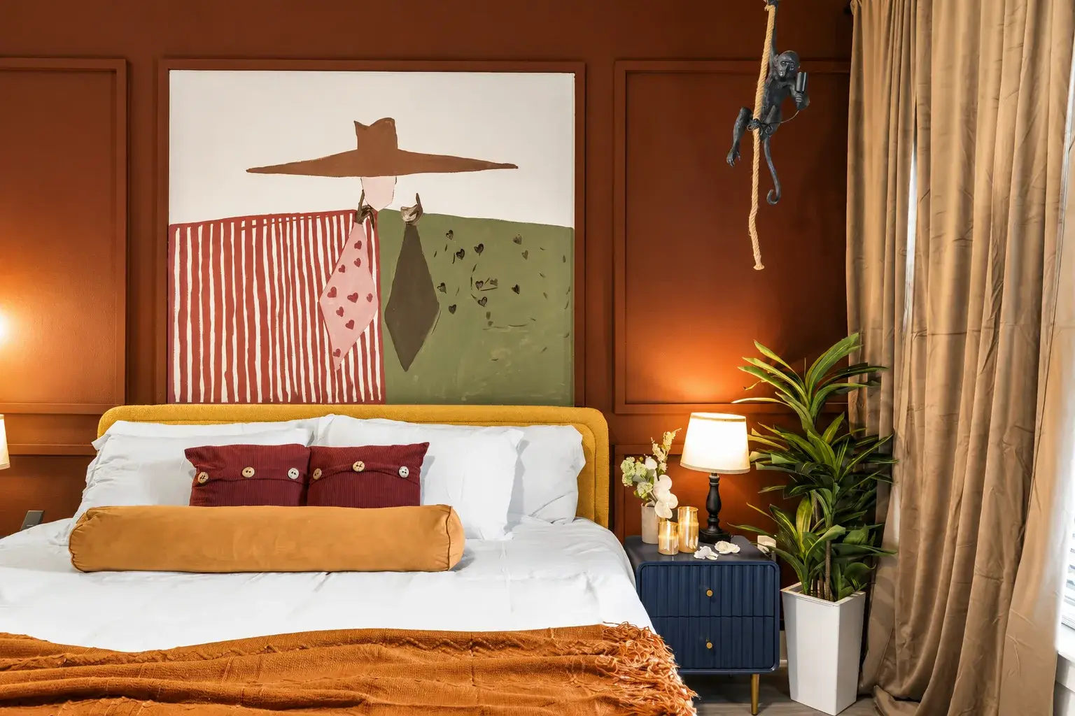 Moody designer bedroom with statement art and warm, cozy touches