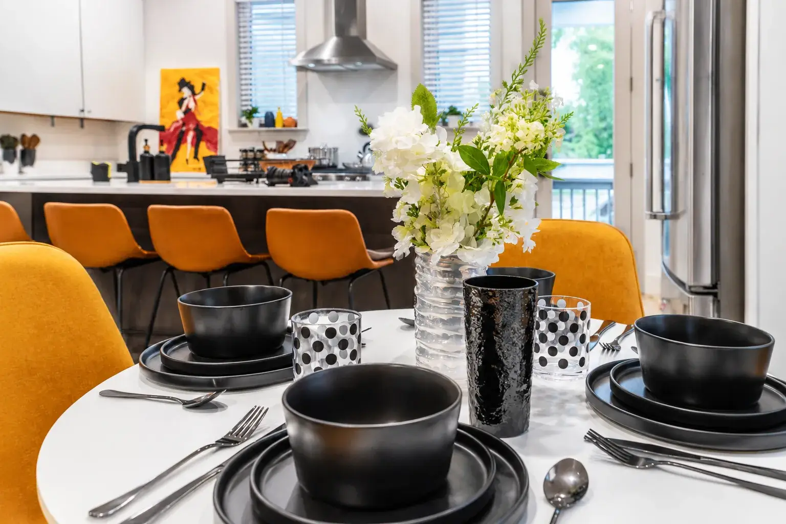 Stylish dining for four beside a bright modern kitchen and island seating