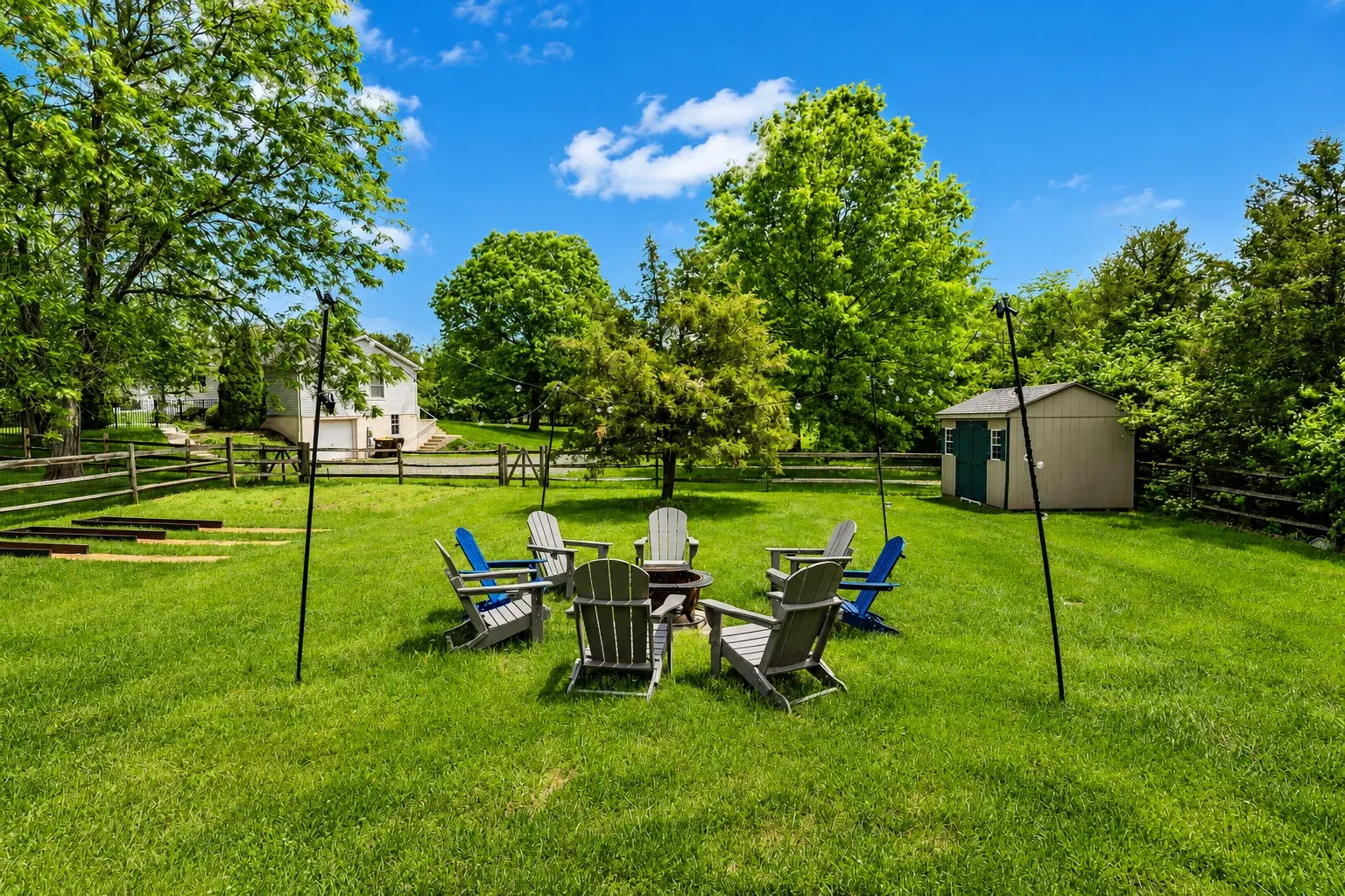 Spacious backyard with fire pit, Adirondack seating, and lush green lawn