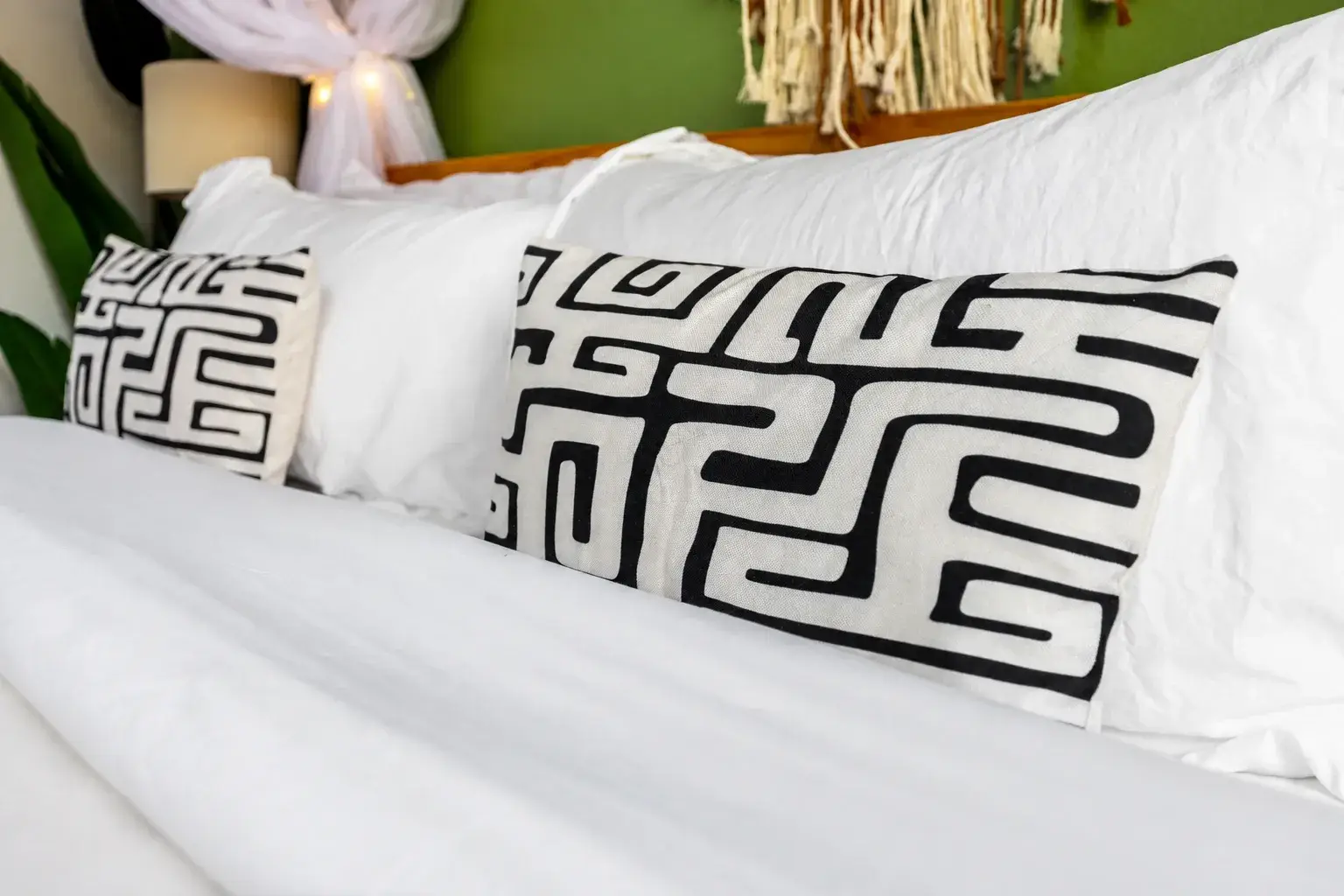 Crisp white bedding with bold accent pillows in a stylish, cozy bedroom