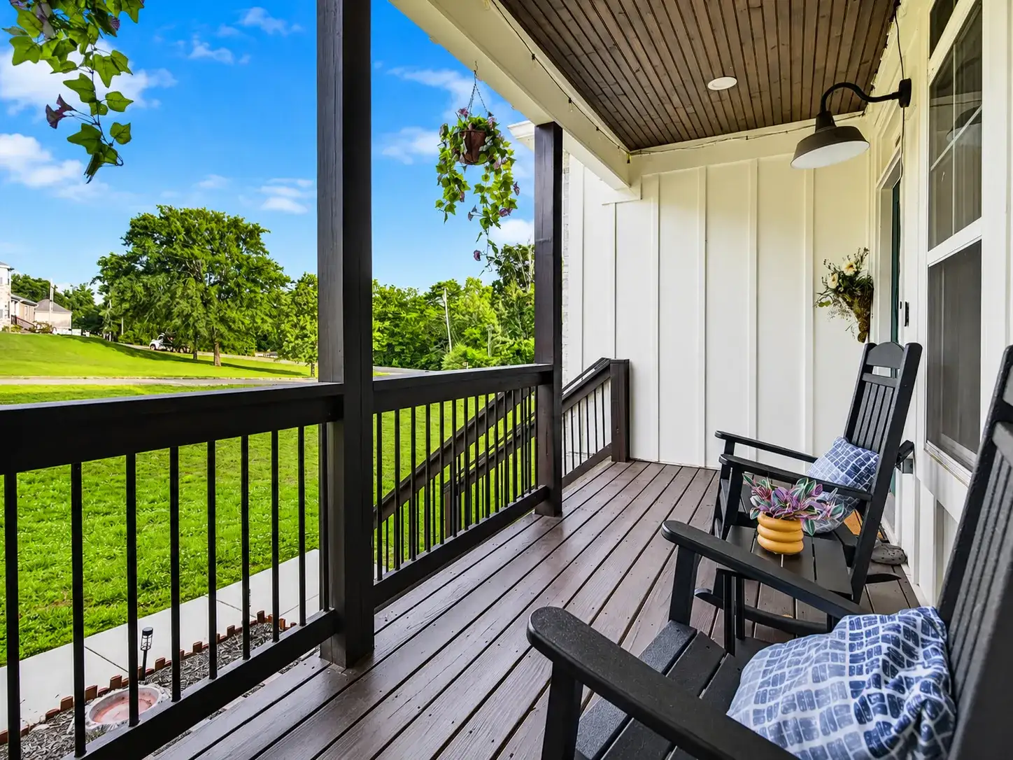 Peaceful covered porch with rocking chairs and scenic green views
