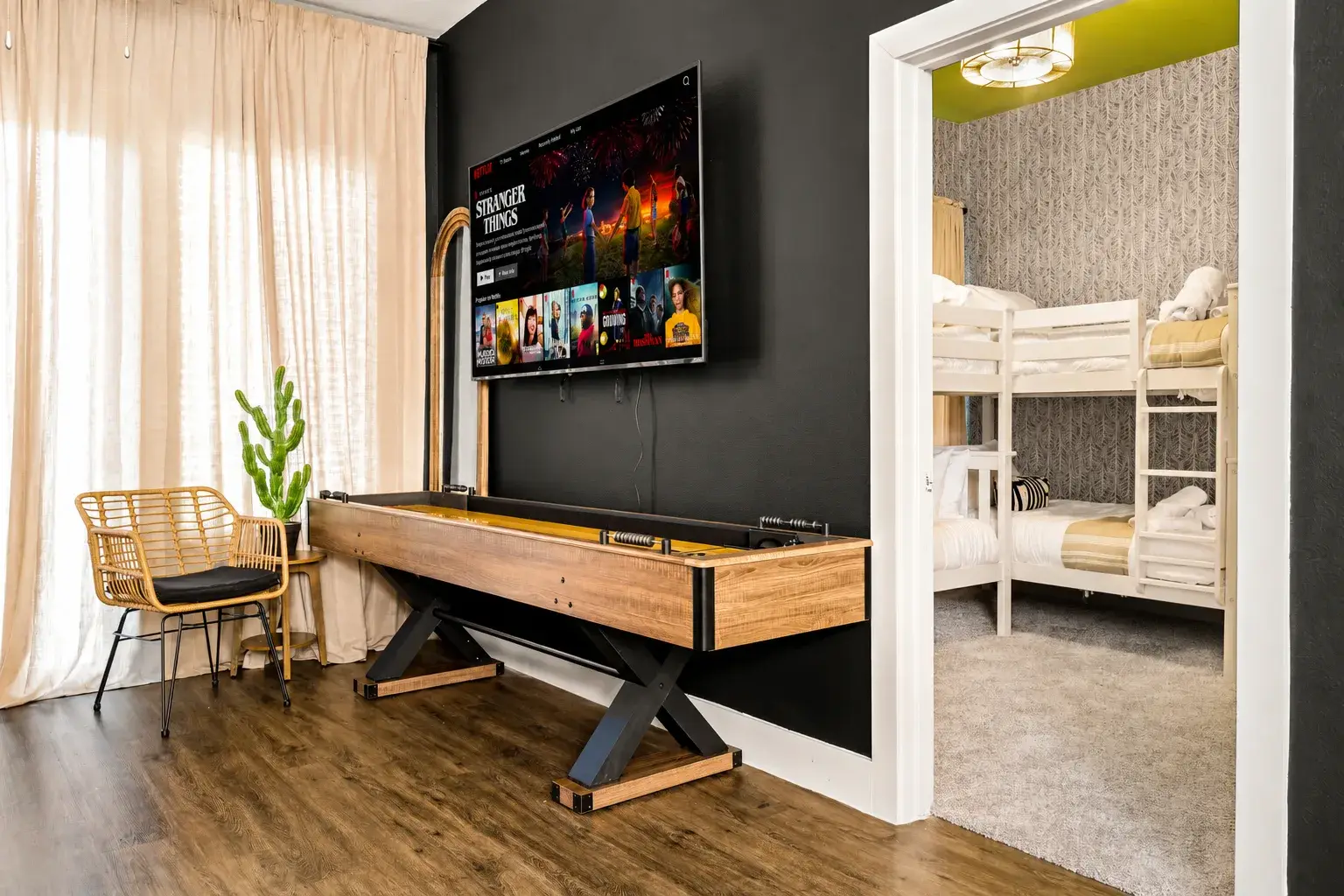 Game room with TV, shuffleboard, and adjoining bunk room for group stays