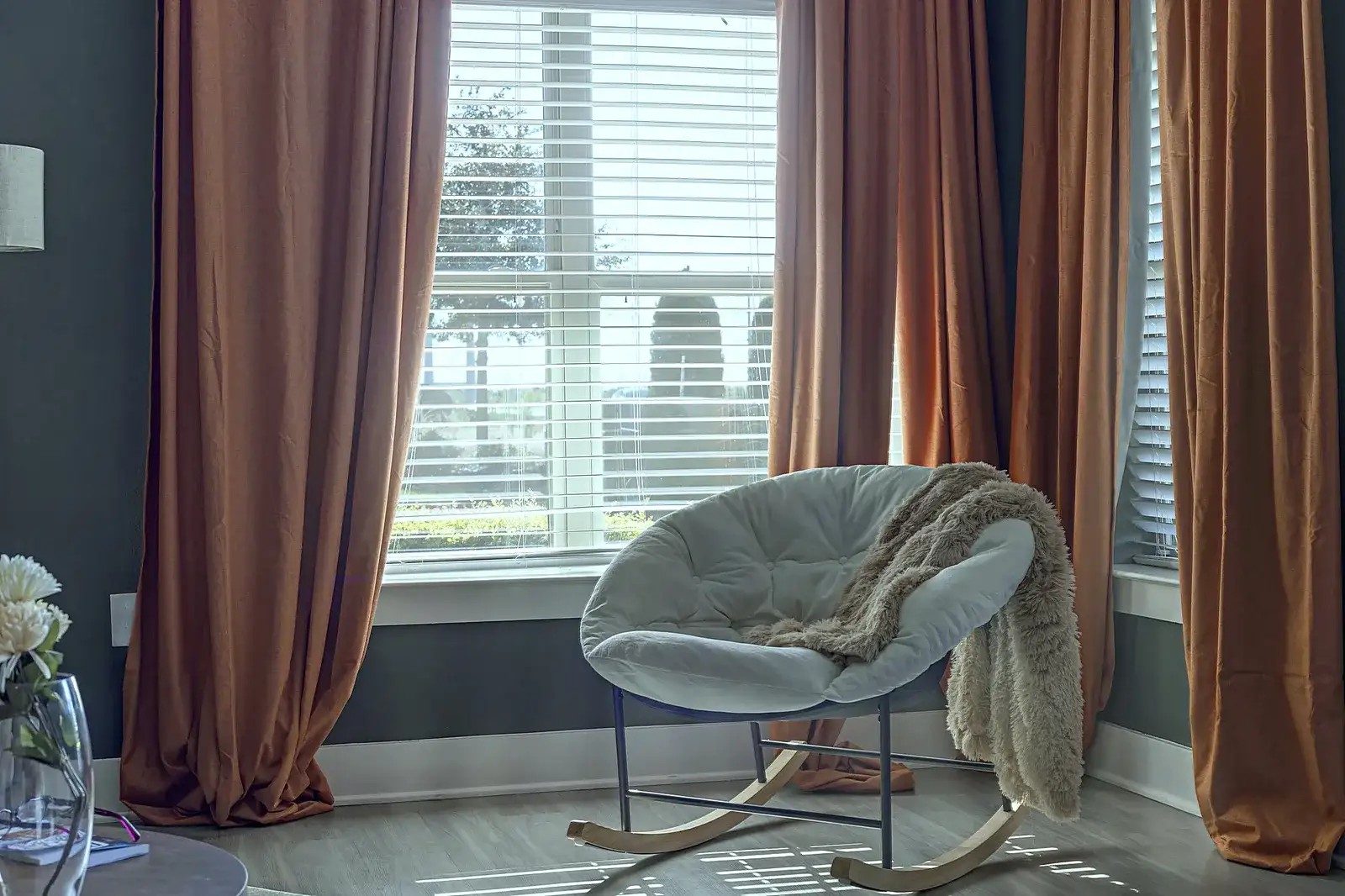 Sunny reading nook with cozy chair, soft throw, and elegant drapes
