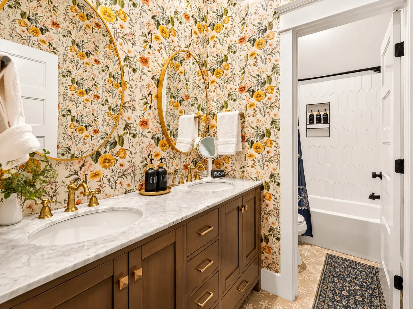 Elegant floral bathroom with double vanity and luxe brass accents