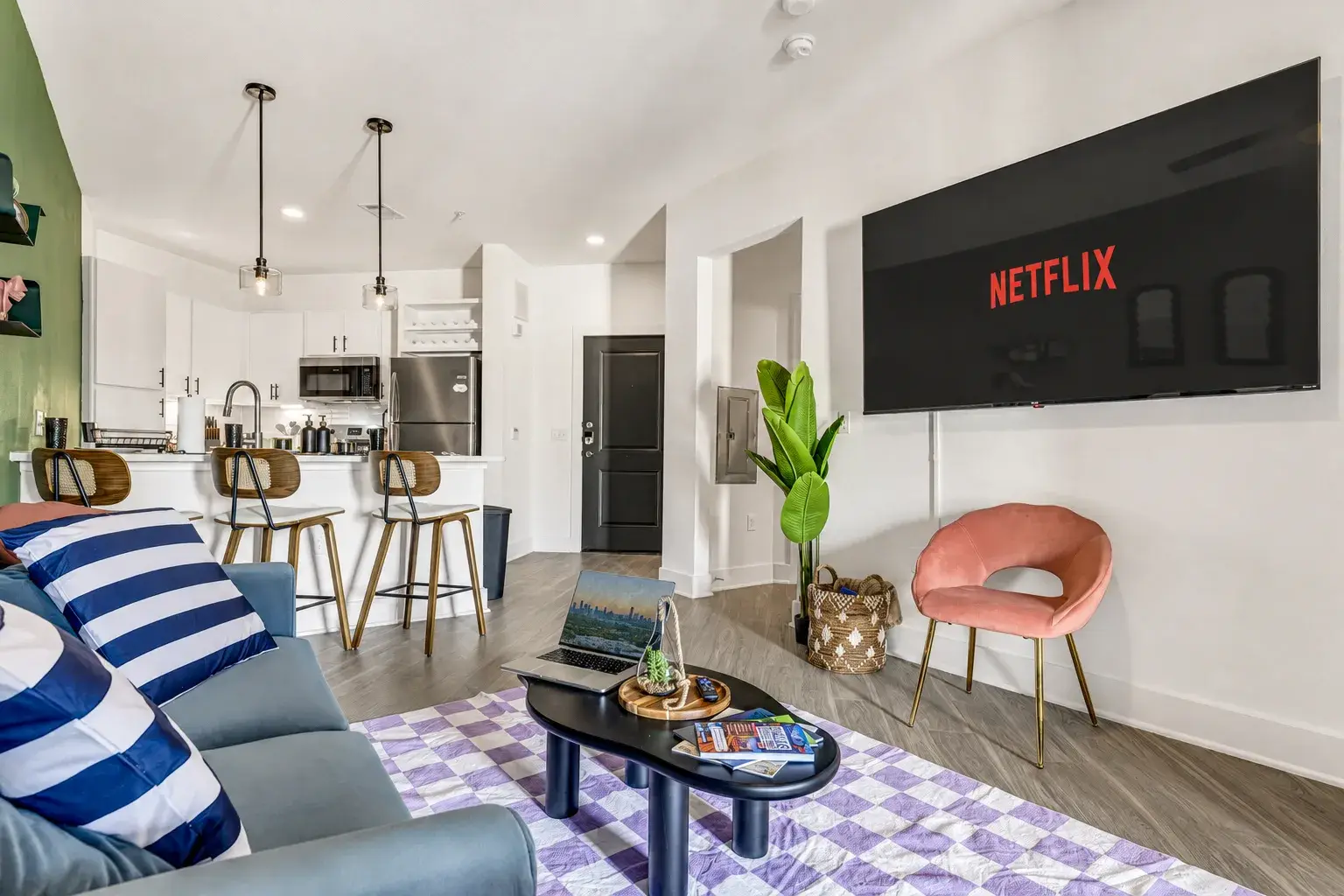 Open plan living and kitchen with a smart TV, bar seating and bright natural light