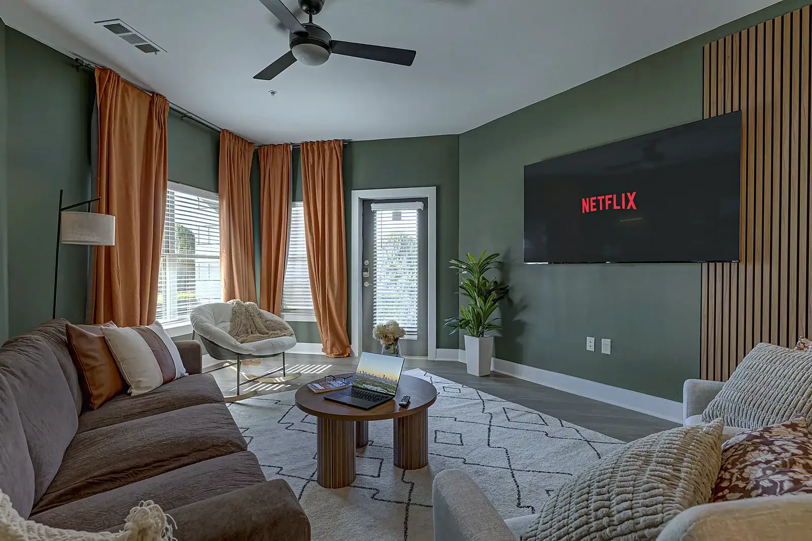 Bright living room with a big smart TV, deep sofa and armchairs for the whole group