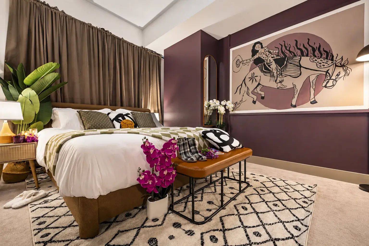 Moody designer bedroom with plush king bed and bold statement art