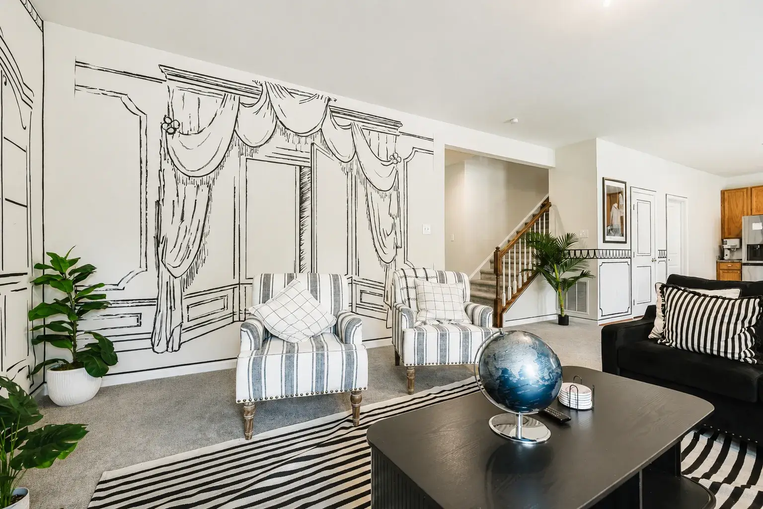 Stylish living room with bold mural wall and chic black-and-white decor