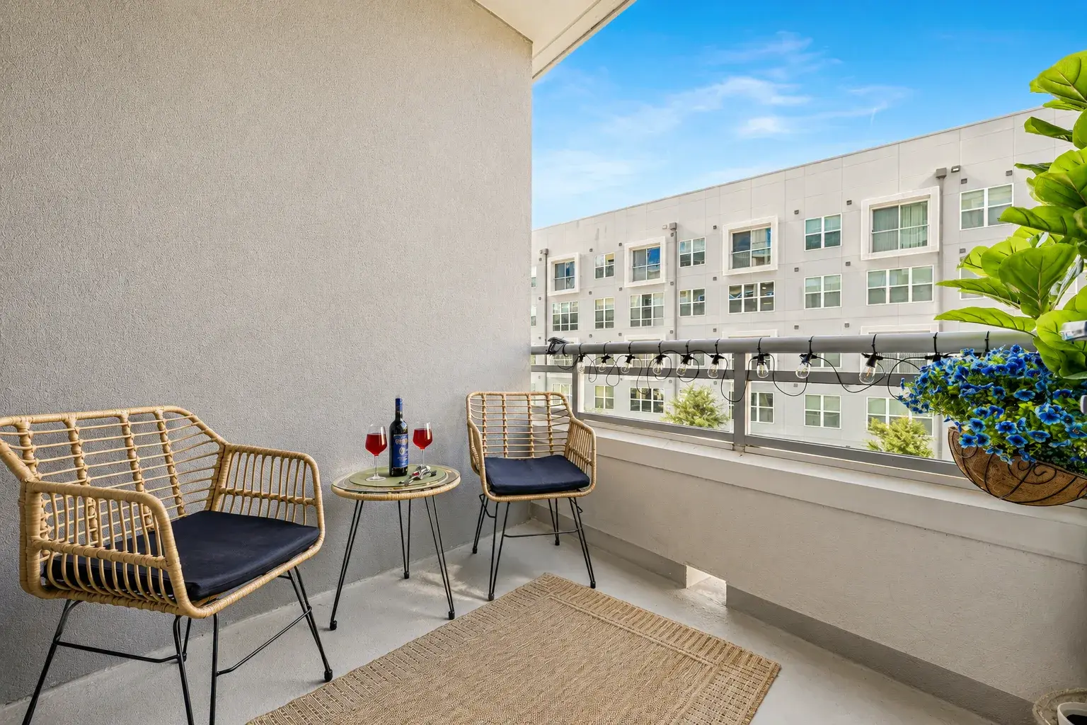 Cozy private balcony with stylish seating, string lights, and wine-ready charm