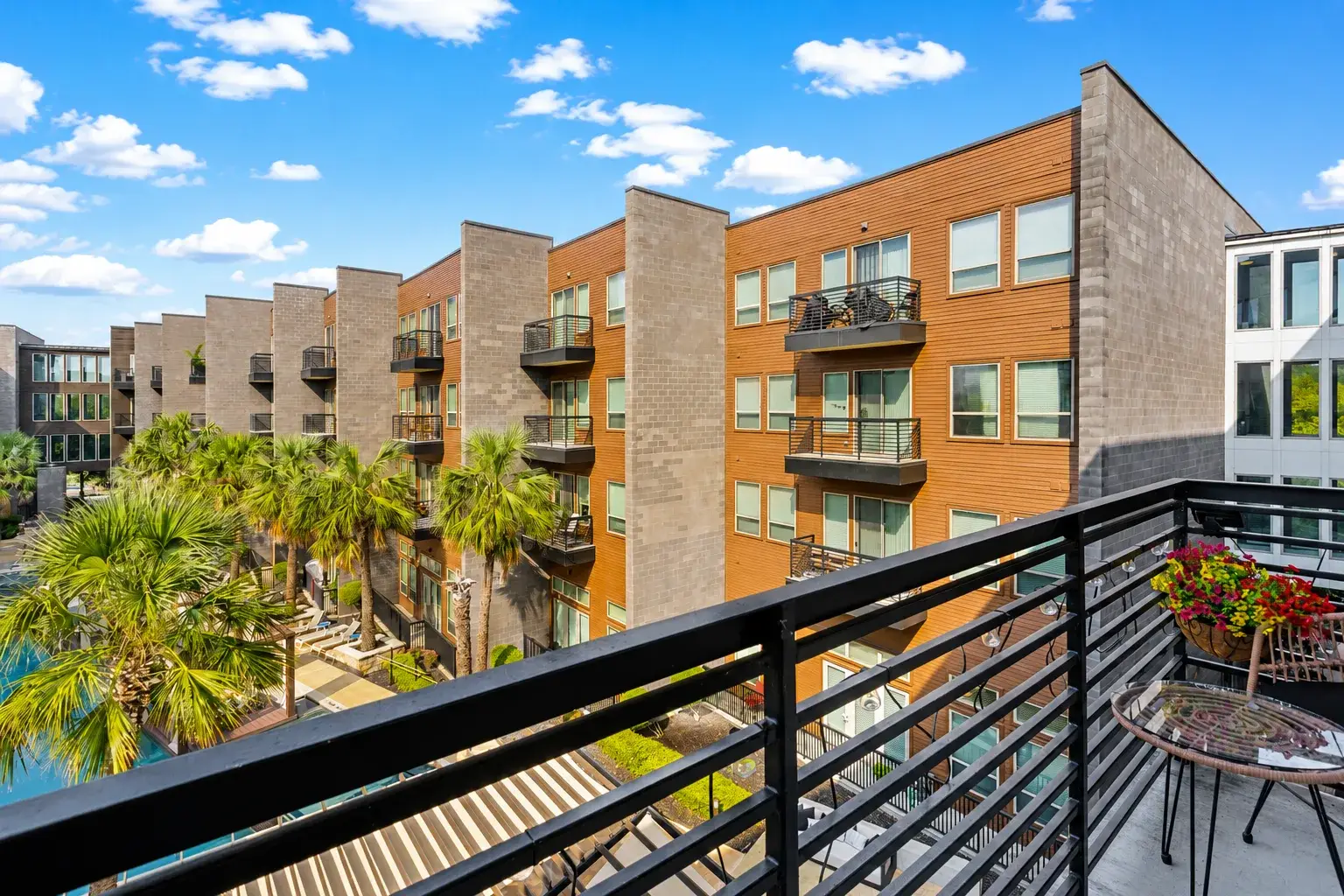 Private balcony with palm-lined courtyard views and a bright resort-style vibe