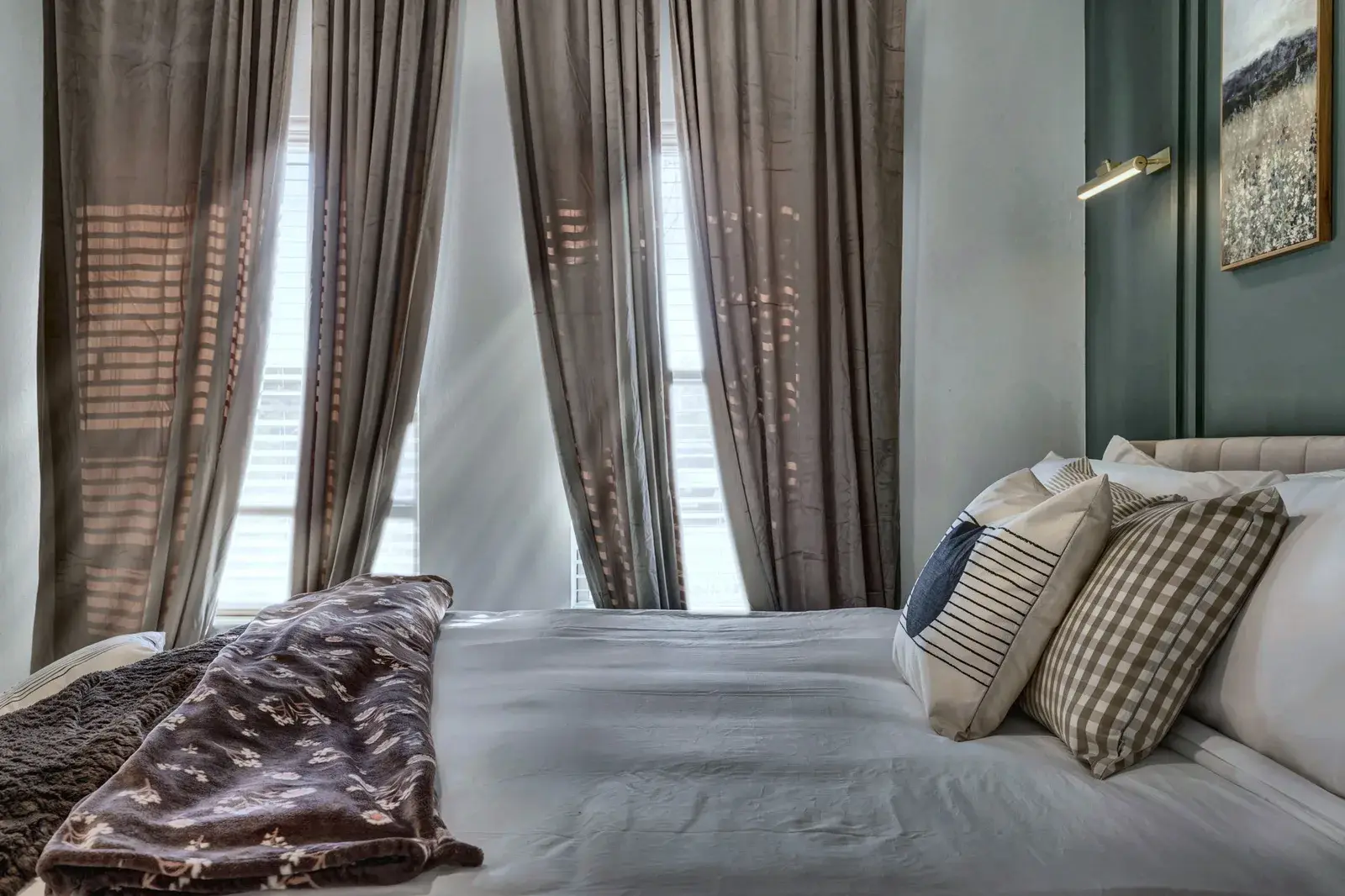 Cozy, light-filled bedroom with elegant drapes and plush bedding