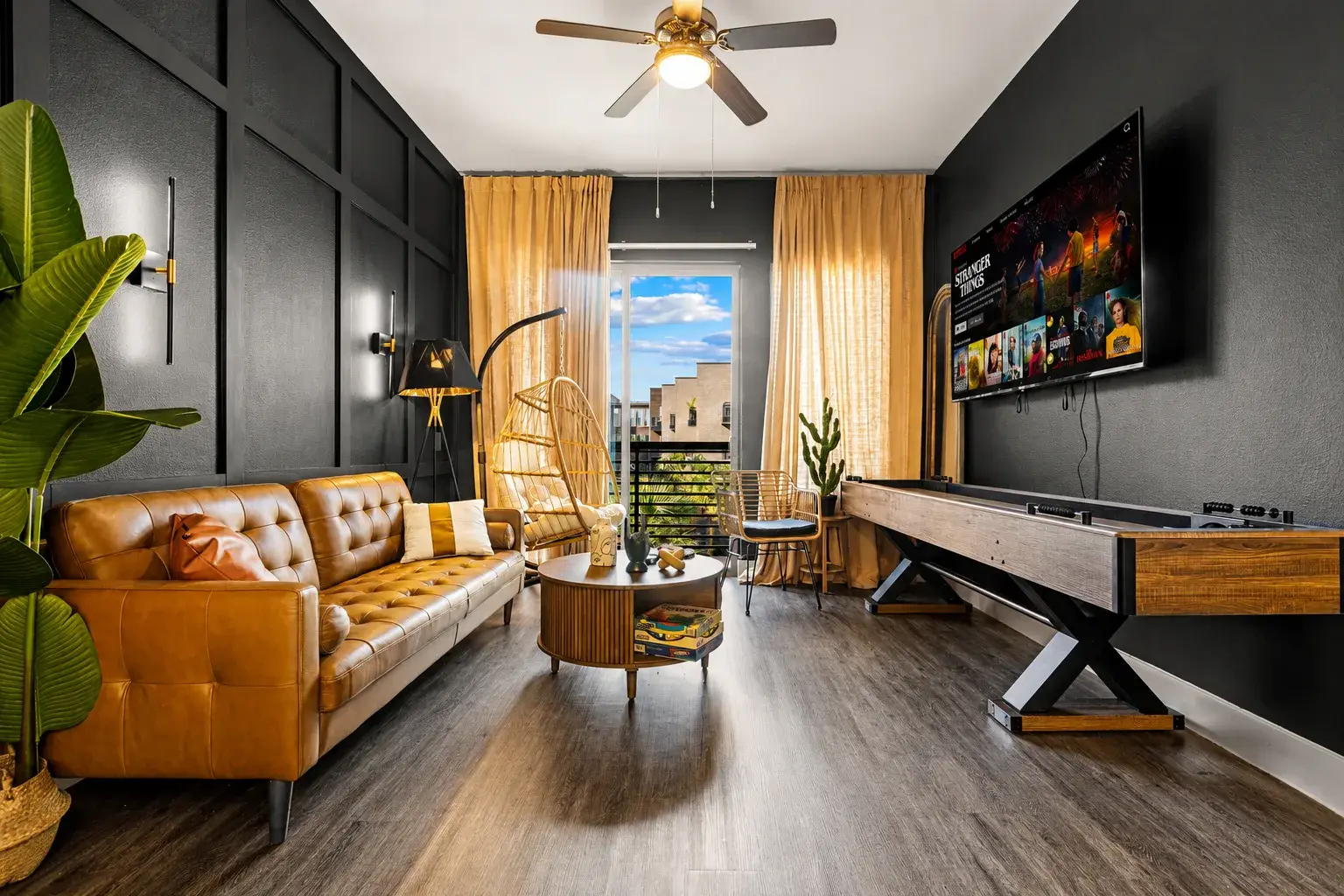 Stylish lounge with city views, smart TV, and in-room shuffleboard fun