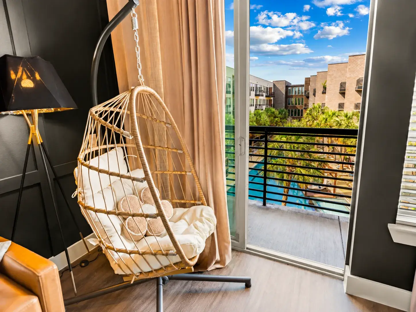 Cozy hanging chair and private balcony with sunny poolside views