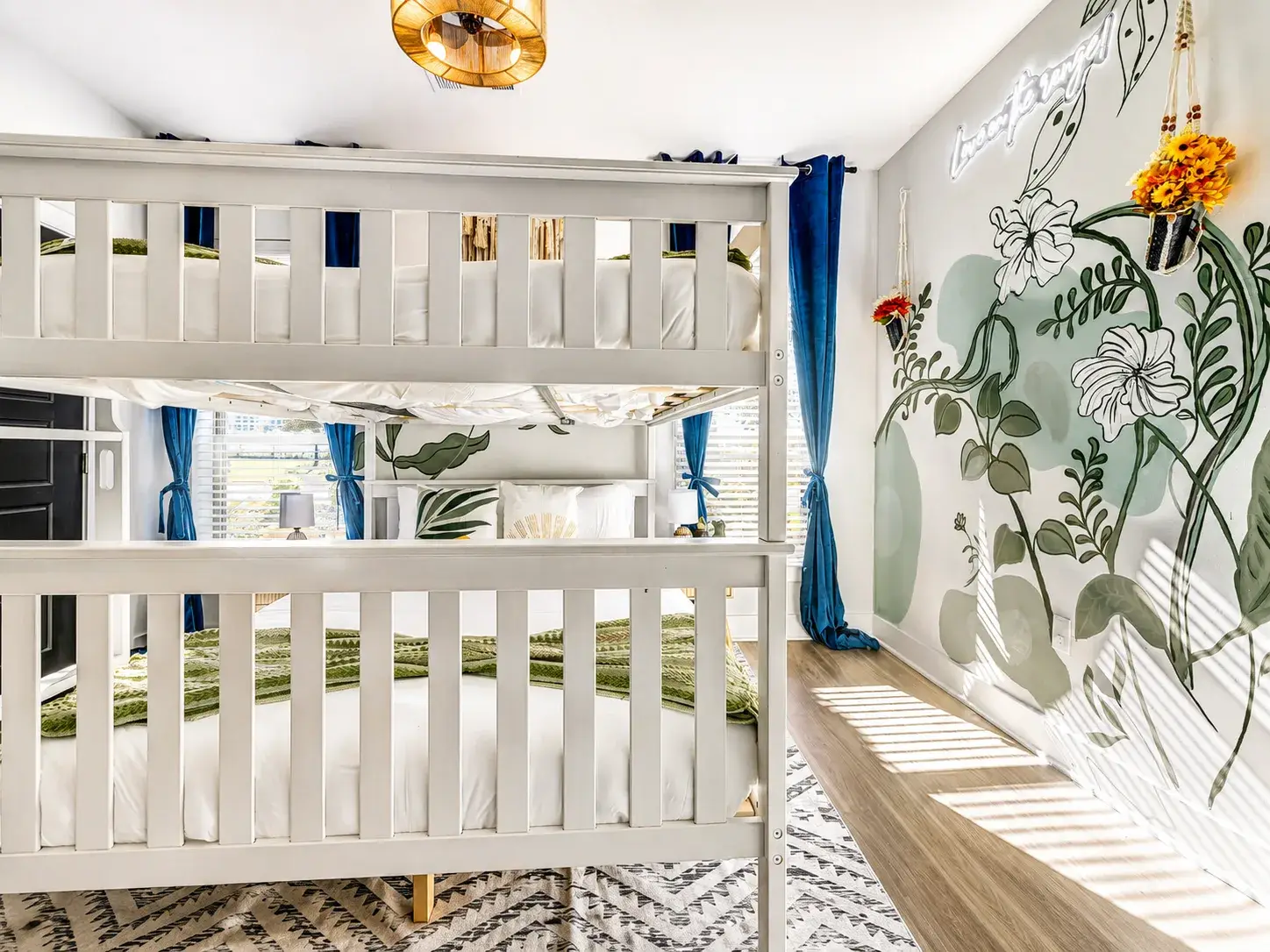 Bright bunk room with floral mural, natural light, and stylish family appeal