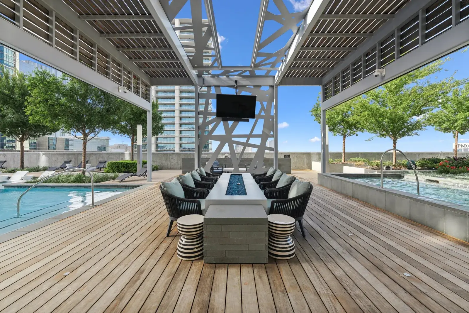Rooftop pool deck with fire-table dining, TV lounge, and city views
