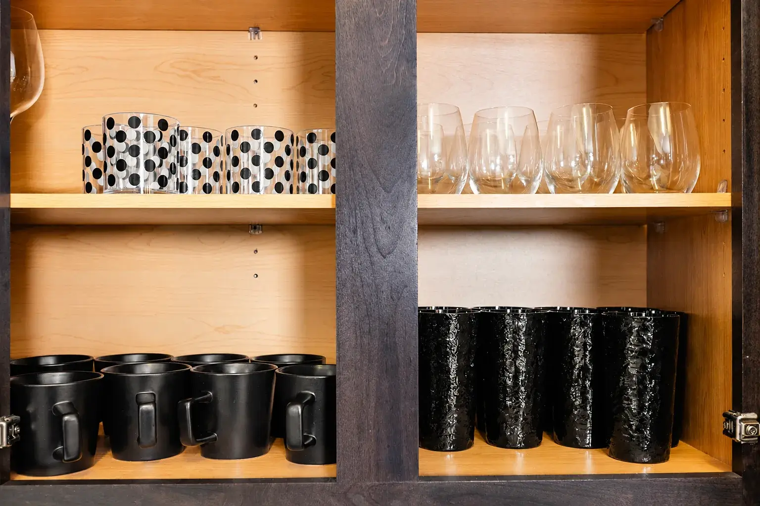 Well-stocked drinkware cabinet with stylish mugs, tumblers, and wine glasses
