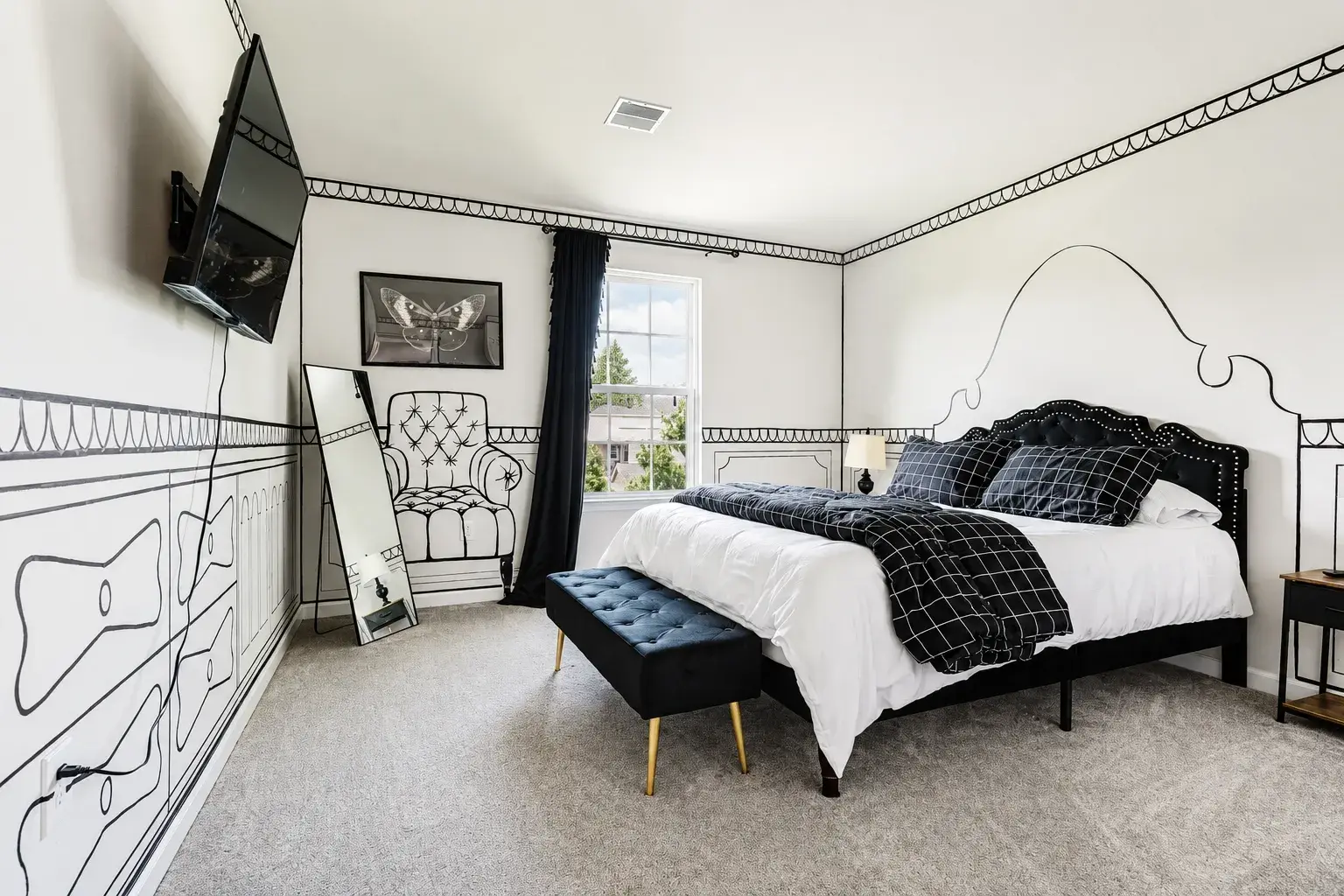 Stylish black-and-white bedroom with bold design and natural light