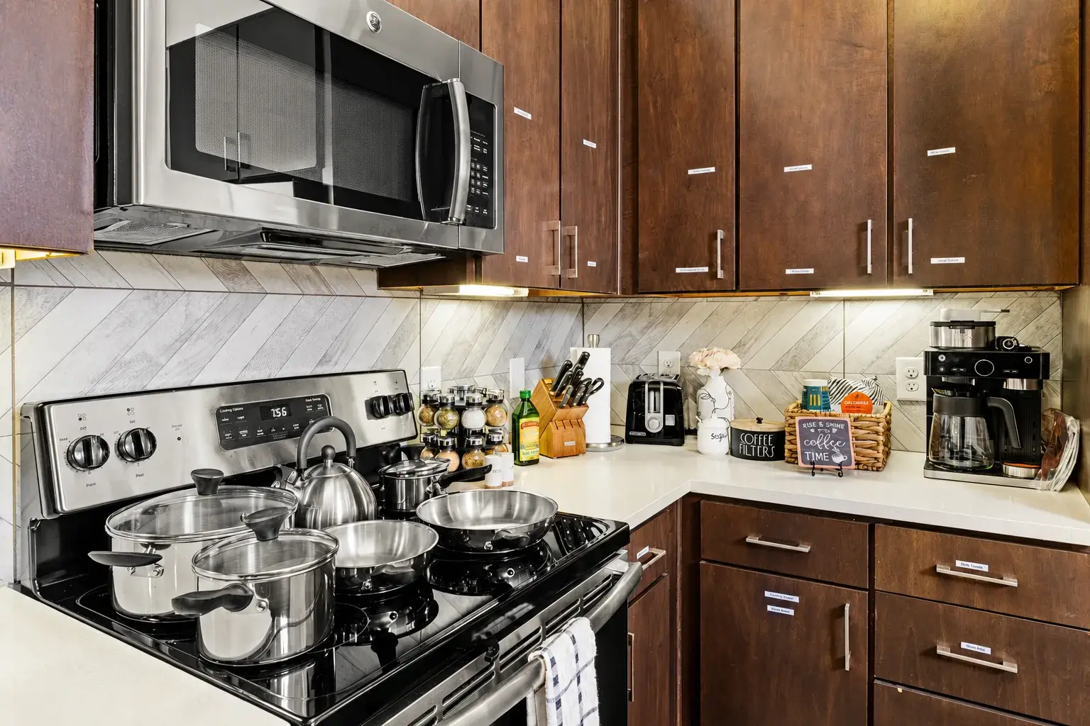 Modern full kitchen with stainless appliances, coffee station, and ample storage