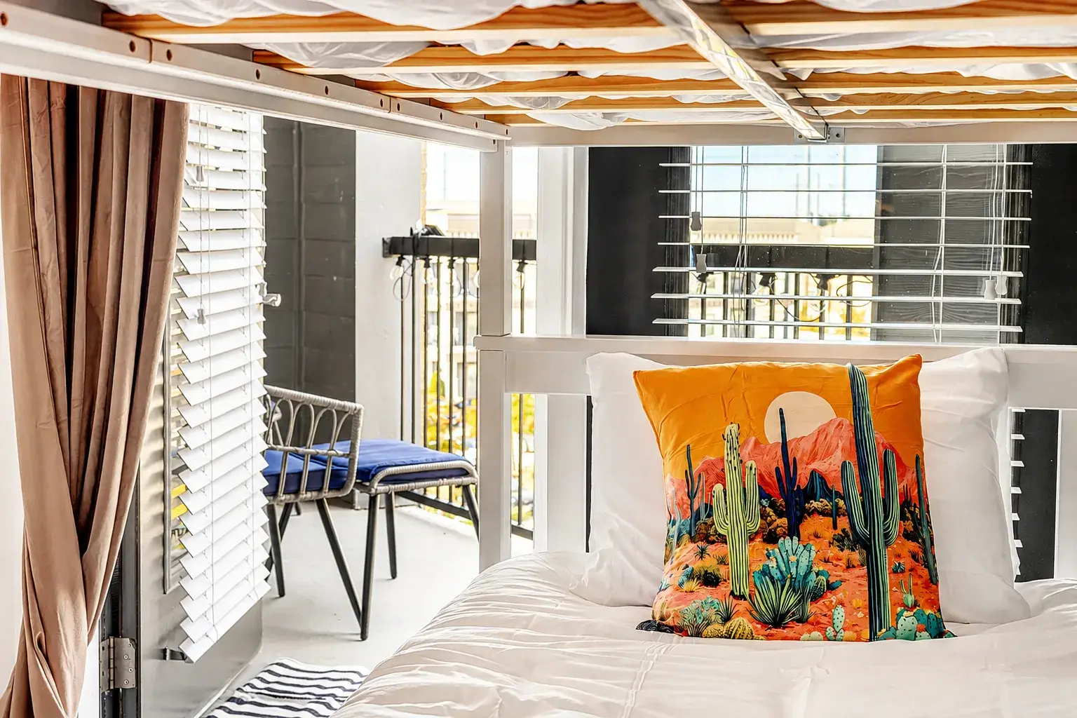 Bright loft bed with private balcony access and colorful desert-inspired decor