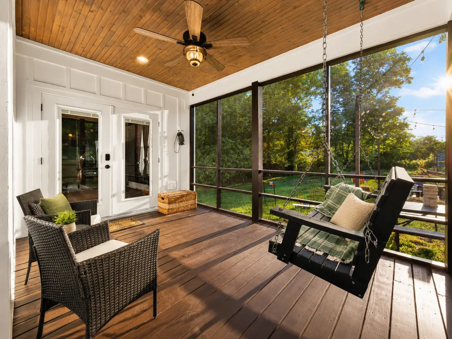 Relax on the screened porch with swing seating and serene tree views