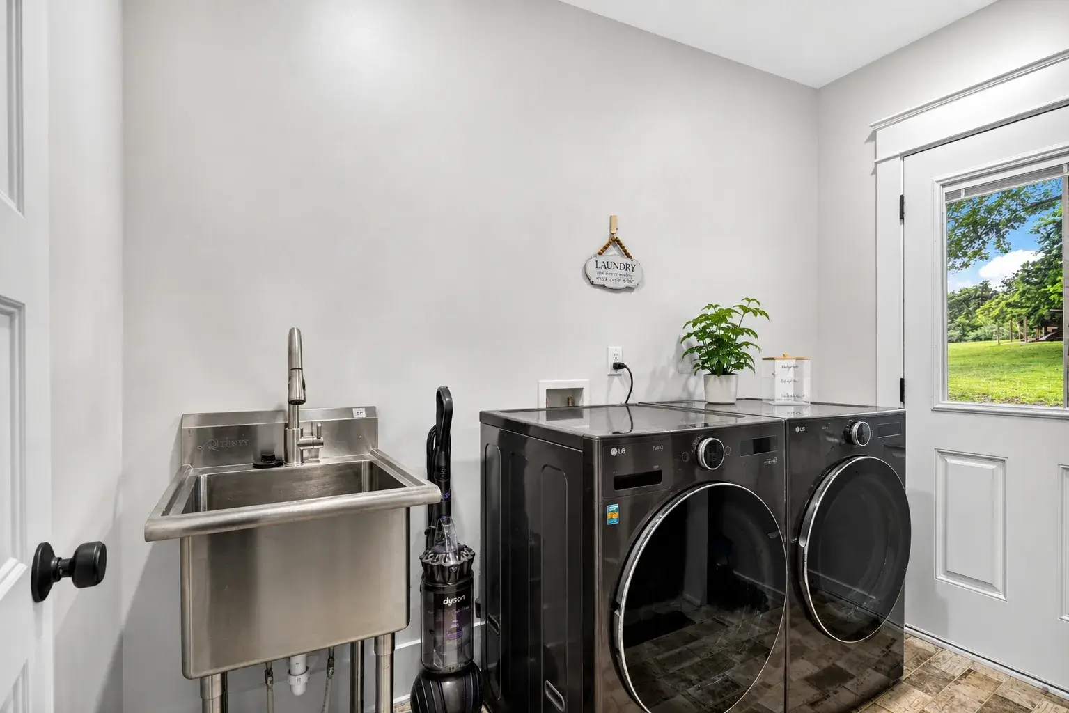 Bright modern laundry room with full-size washer, dryer & utility sink