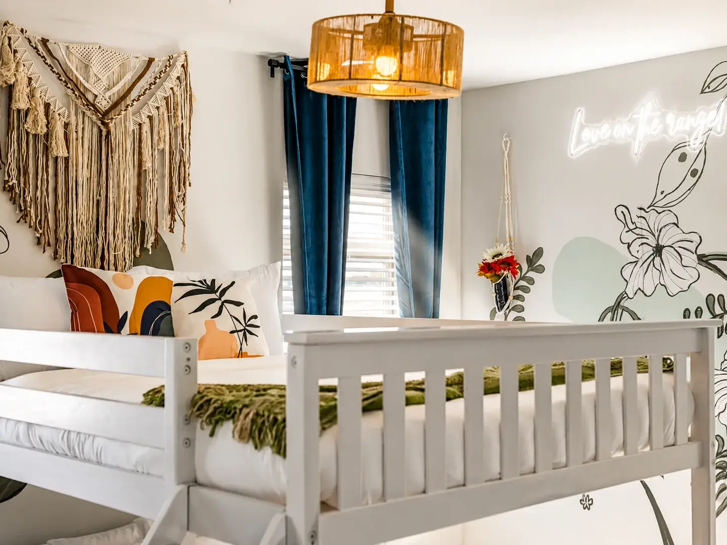 Boho-chic bedroom with neon wall art and cozy, stylish details